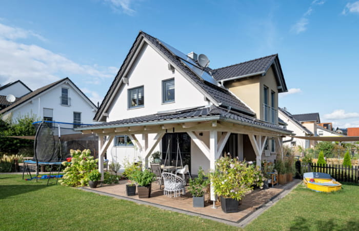 Einfamilienhaus von Schopf & Teig mit überdachter Terrasse und Garten.