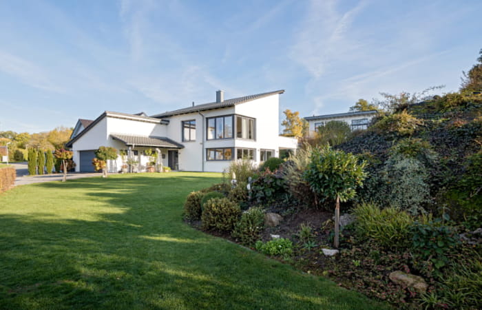 Modernes Einfamilienhaus von Schopf & Teig mit großen Fensterflächen und weitläufigem, gepflegtem Garten.
