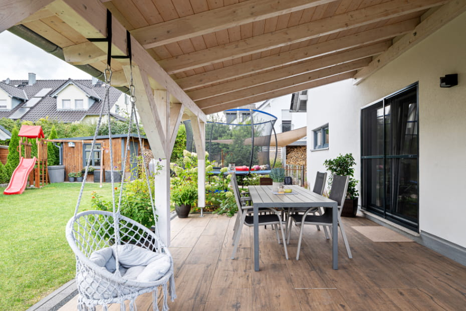 Überdachte Terrasse eines Einfamilienhauses von Schopf & Teig mit Garten und Essbereich.
