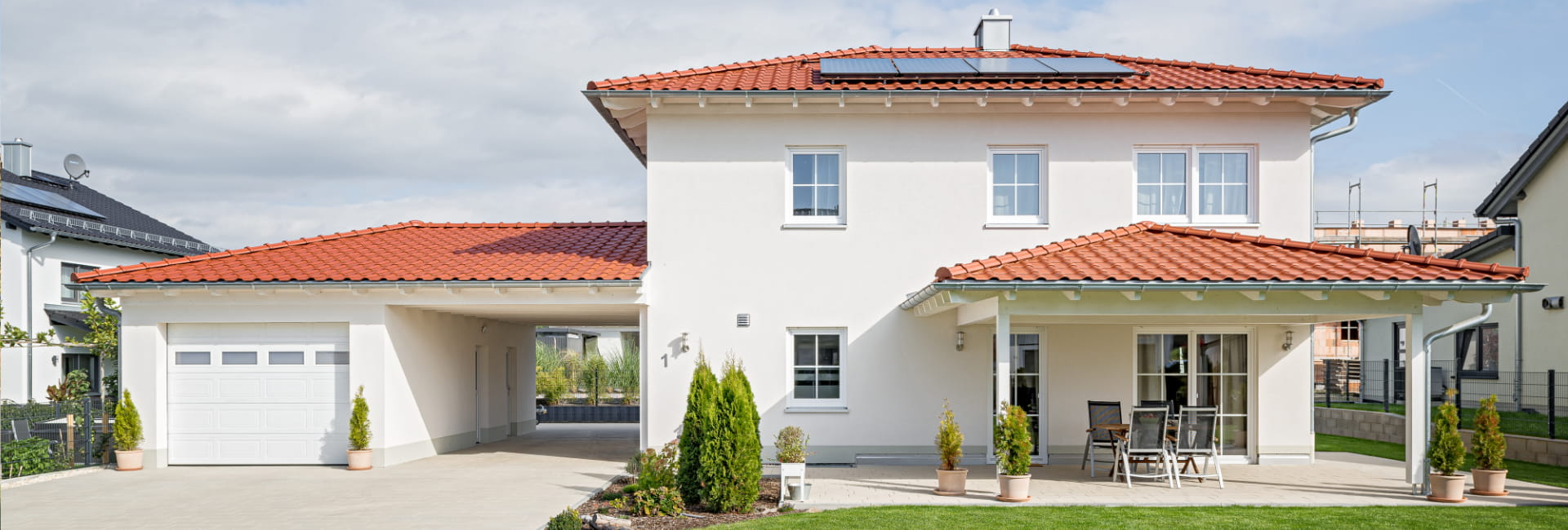 Einfamilienhaus von Schopf & Teig mit Walmdach, Garage, Terrasse und Photovoltaikanlage.